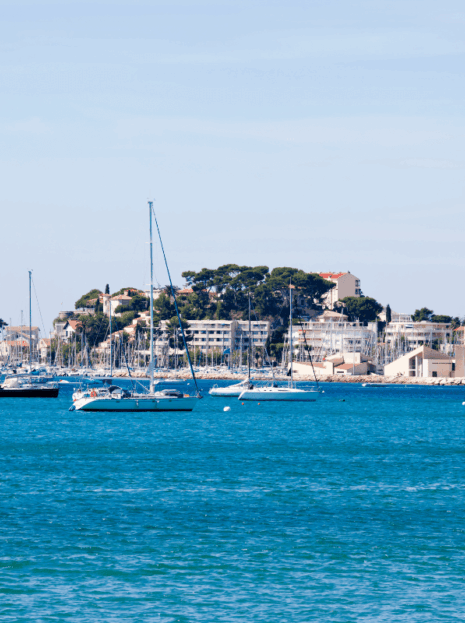 View of Bandol and Sanary-sur-Mer’s charming harbors with boats, markets, and colorful façades on a sunny day